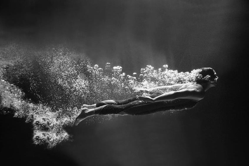 Woman diving and swimming under water