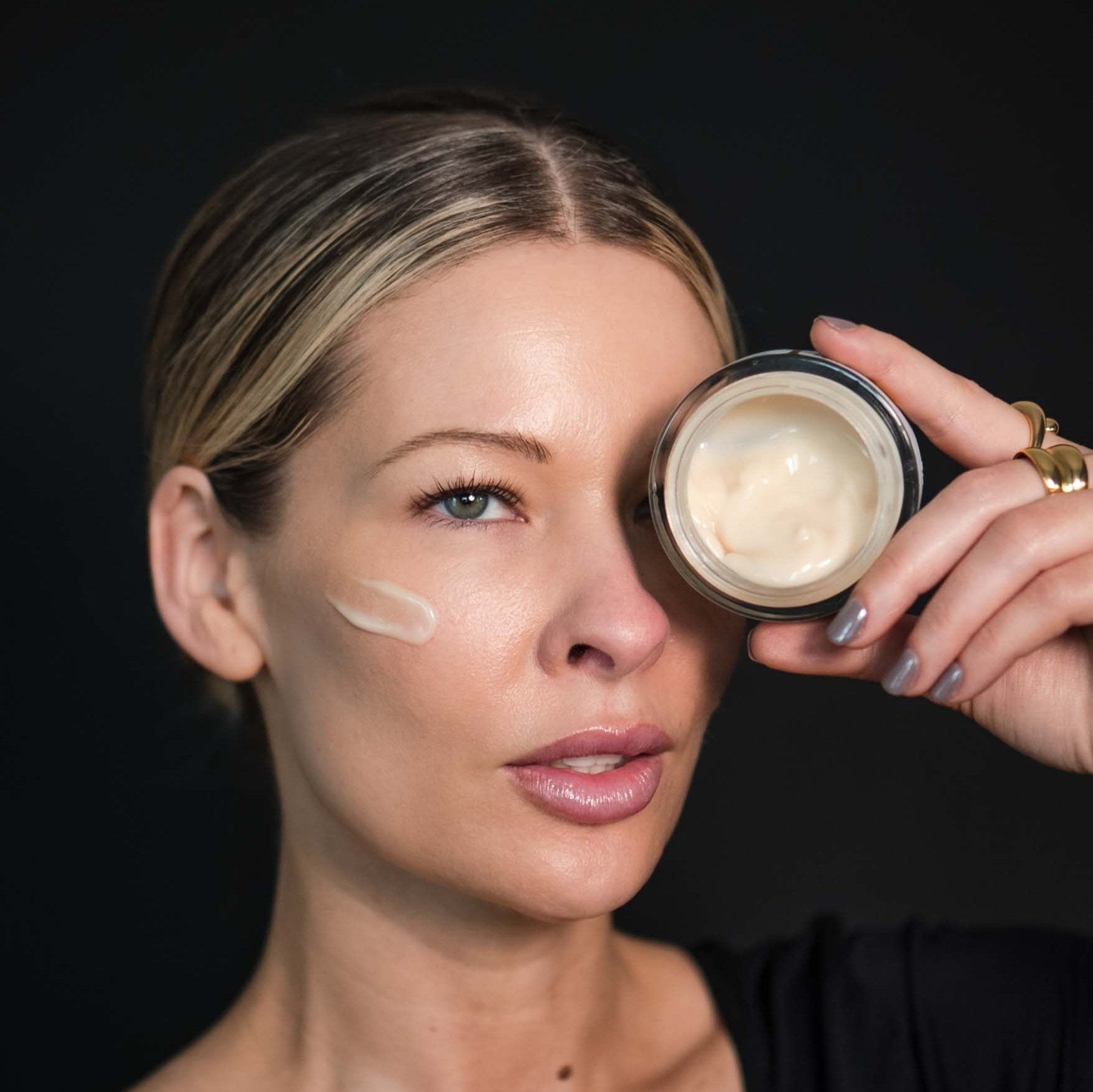 Model applying Antidote Moisturizer by Intoxicated Cosmetics for wrinkle reduction